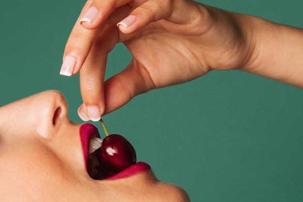 Foto gratuita donna seducente mordere una ciliegia