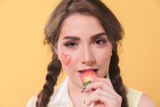 Seductive woman eating a strawberry