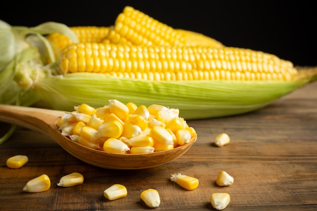 Seeds and sweet corn on wooden table. Free Photo