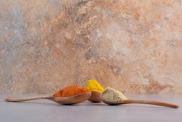 Free photo selection of indian spices in wooden spoons.