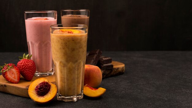 Selection of three milkshake glasses with chocolate and fruits