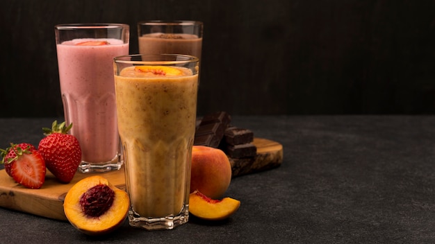 Selection of three milkshake glasses with chocolate and fruits