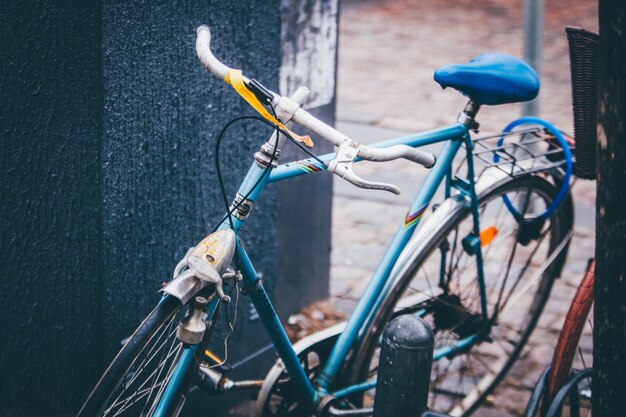 Selective closeup shot of a blue bicycle parked near a wall