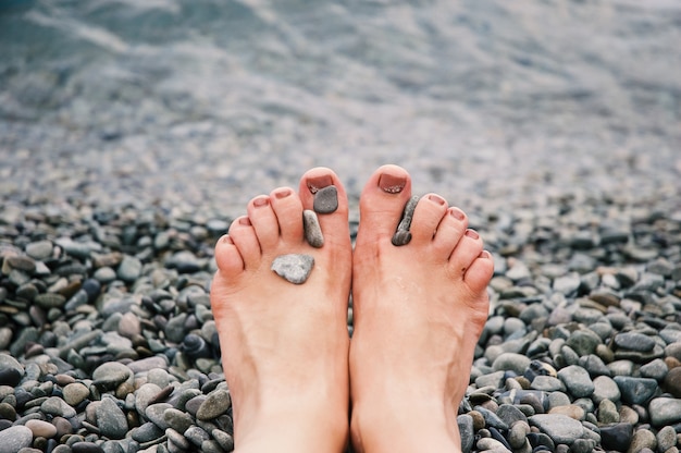 Selective closeup shot of pebbles on a Caucasian person's legs