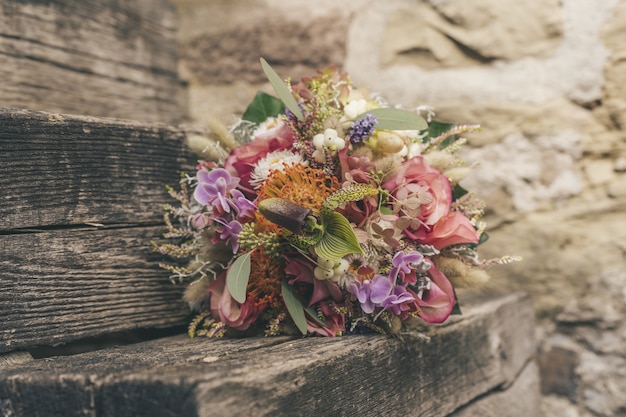 Foto gratuita messa a fuoco selettiva di un bellissimo bouquet di fiori piccoli su una superficie di legno