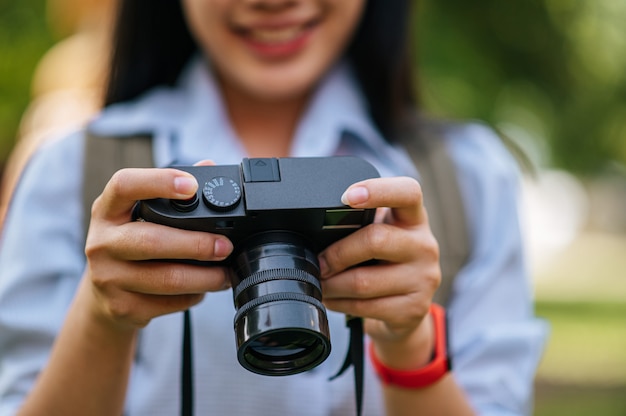 선택적인 초점, 여행하는 동안 디지털 카메라를 들고 있는 젊은 사진작가 여성의 손을 클로즈업, 공간 복사