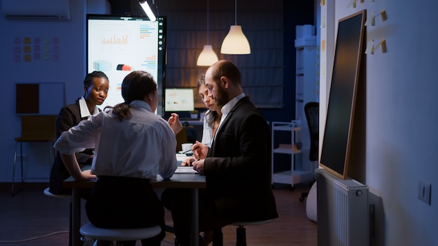 Free photo selective focus of diverse multiethnic businesspeople overworking late at night