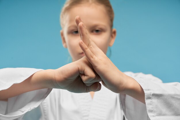 Selective focus of fist of little female fighter in studio