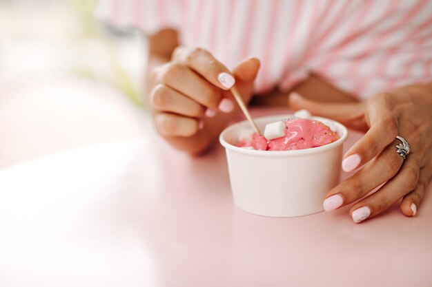 Selective focus of girl eating ice cream with marshmallow Cropped view of woman with dessert