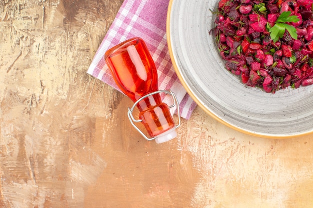 Selective focus healthy vegetable salad with olive oil dressing in a red bottle on a background with copy space