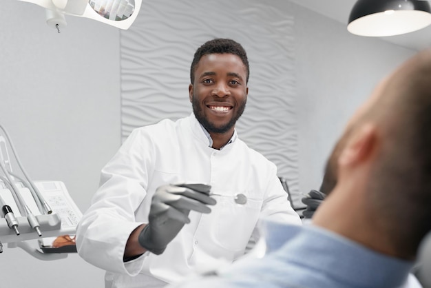 Selective focus of male dentist in process of curing teeth