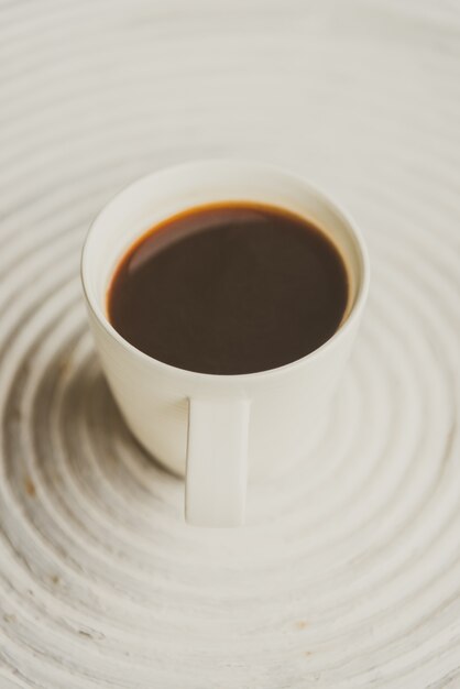 Foto gratuita punto di messa a fuoco selettiva su caffè nero in tazza bianca