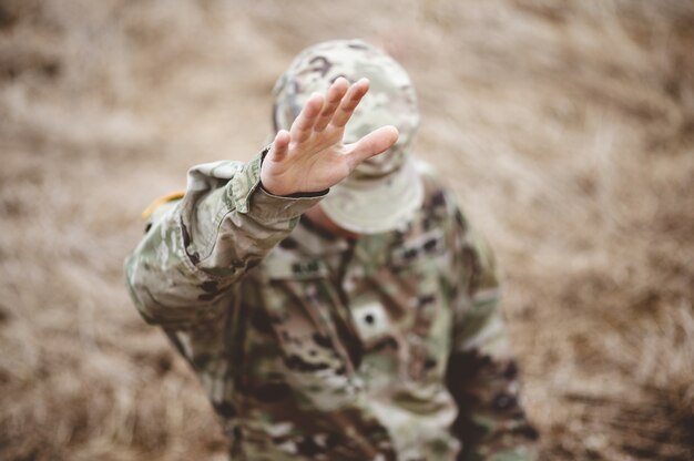 Selective focus shot of an American soldier with his hand raised above