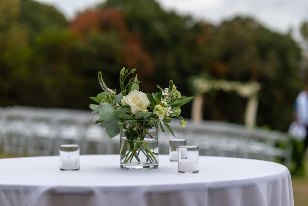Selective focus shot of beautiful flowers in a vase on a table at a wedding ceremony