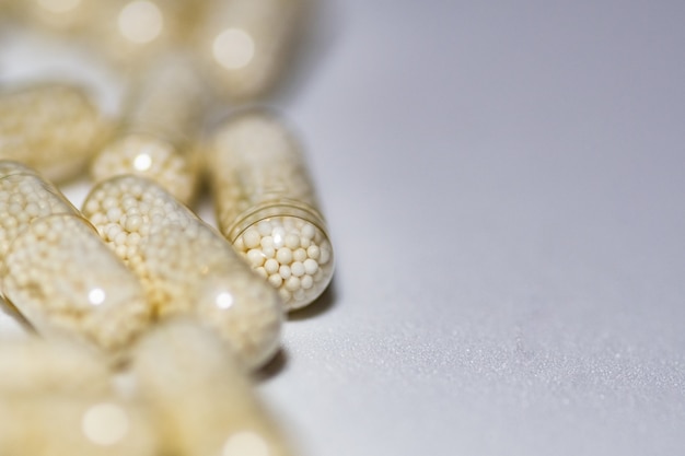 Selective focus shot of capsules pm a white surface