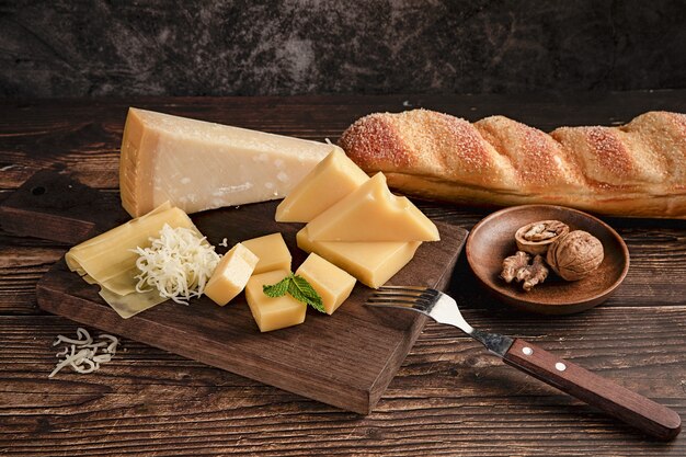 Selective focus shot of a delicious cheese platter on the table with walnuts and bread on it