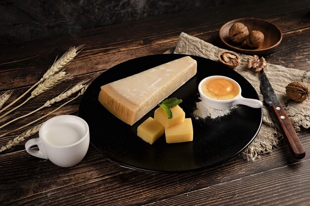 Селективный снимок вкусного сырного ассорти на столе с грецкими орехами
