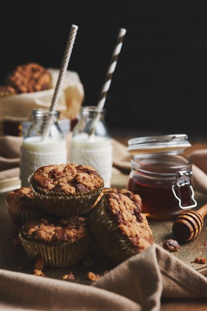 Selective focus shot of delicious Christmas cookie muffins on a plate with honey and milk