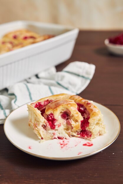 Selective focus shot of delicious currants snail pastries on a plate on a wooden table