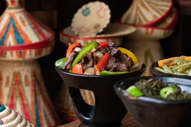 나무 테이블에 신선한 야채와 함께 맛있는 에티오피아 음식의 선택적 초점 샷