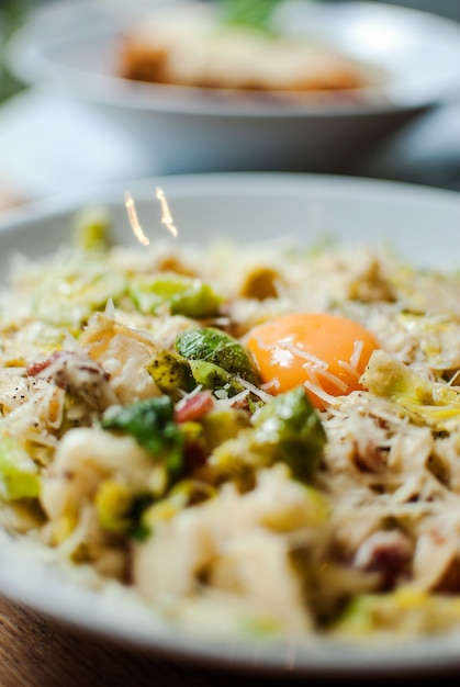 Selective focus shot of delicious pasta with cheese vegetables and egg