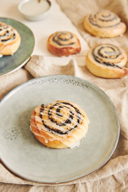 Selective focus shot of delicious poppy seed rolls with a sugar glaze on a table