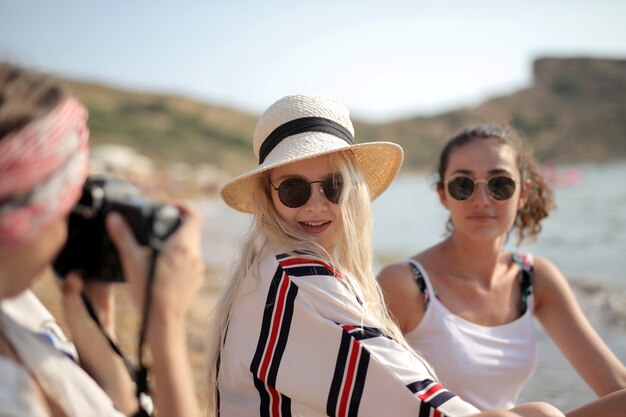 Selective focus shot of a female taking photo of her two best friends