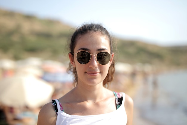 Selective focus shot of a female with glasses at the beach
