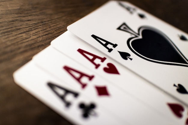 Selective focus shot of four aces on a wooden table