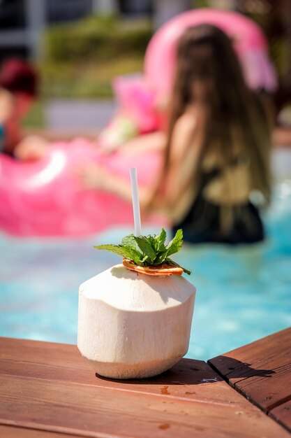 Selective focus shot of fresh coconut drink with drinking straw