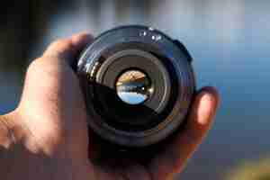 Free photo selective focus shot of a person holding a camera lens