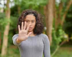 Free photo selective focus shot of a serious determined female showing stop sign