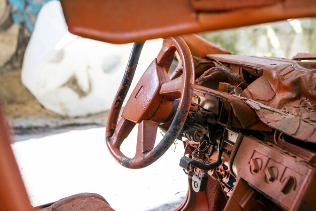 Selective focus shot of a steering wheel of a rusty car