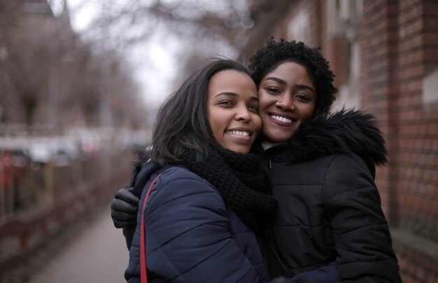 Selective focus shot of two hugged female friends in the street