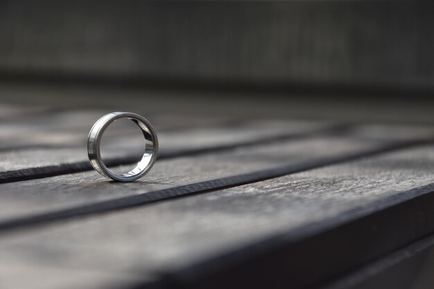 Selective focus shot of a wedding ring on a wooden surface