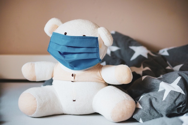 Free photo selective focus shot of a white stuffed teddy bear with a mask