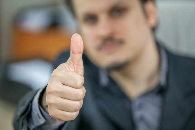 Selective focus shot of a young businessman showing thumbs up