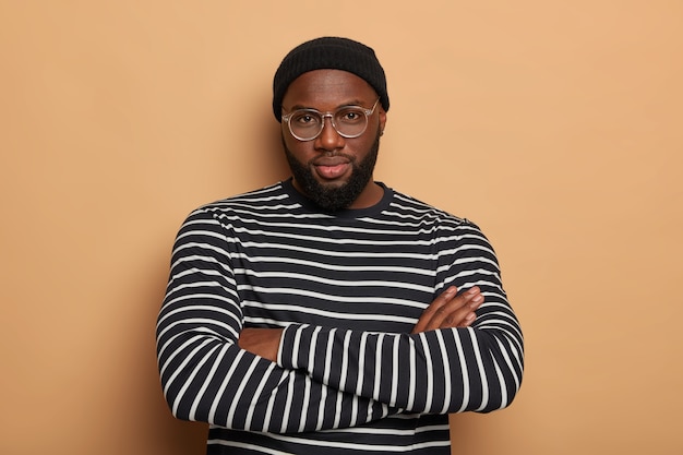 Free photo self-assured bearded male youngster stands with hands crossed