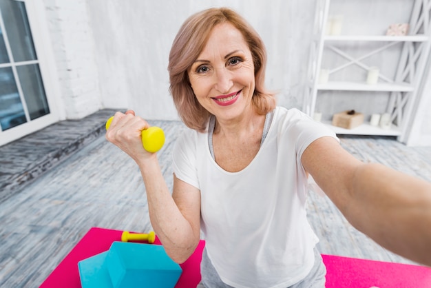 Self portrait of a beautiful woman exercising with dumbbells