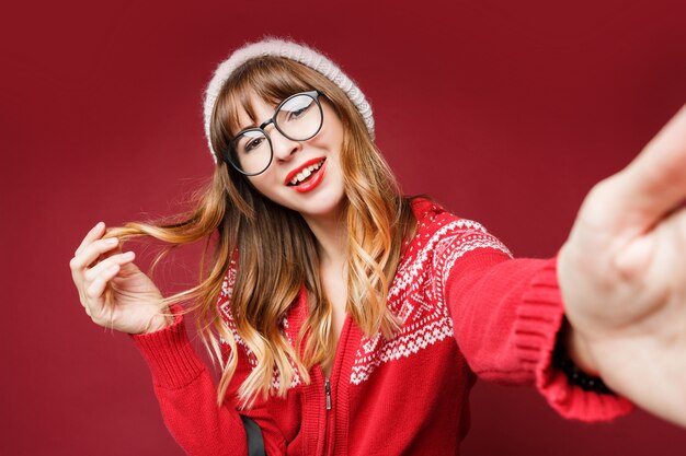 Self portrait of happy long-haired woman in winter clothes