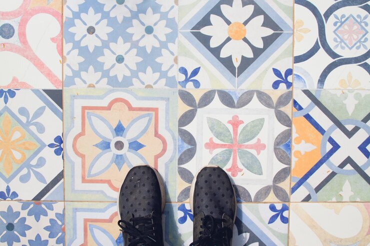 Free Photo selfie of feet with sneaker shoes on vintage art pattern tiles floor, top view