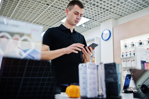 Foto gratuita consulente professionale del telefono cellulare dell'uomo del venditore nel negozio o nel negozio di tecnologia