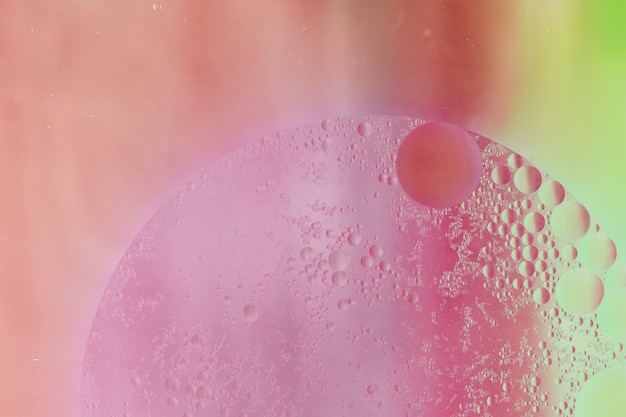 ピンク​の​背景​に​水滴​で​作られた​半円