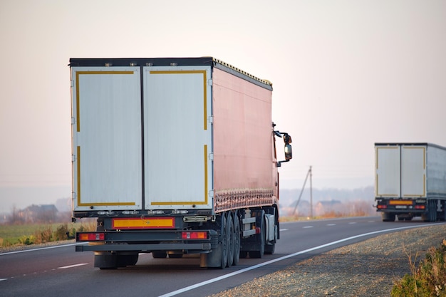 Полуприцеп с грузовым прицепом едет по шоссе, перевозя грузы вечером. концепция транспортировки и логистики доставки.