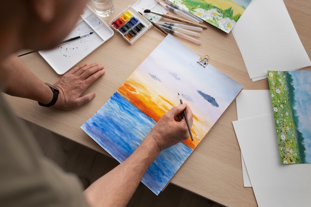 Senior artist in the studio painting with watercolor