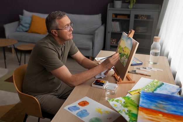 Free photo senior artist in the studio painting with watercolor