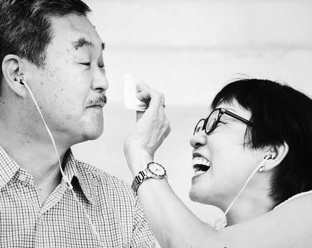 Senior Asian couple listening to music together