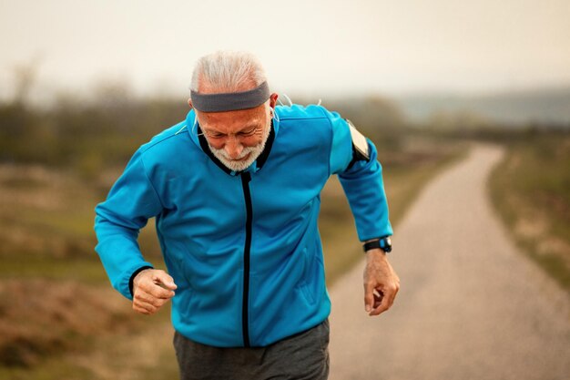 Старший спортивный мужчина бегает по утрам на природе