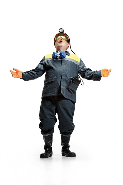 senior bearded male miner standing at the camera on a white