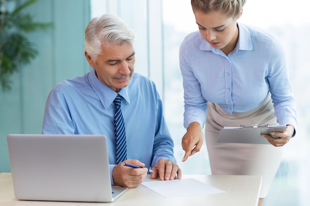 Free photo senior boss and secretary discussing document